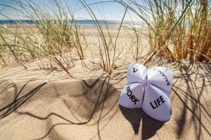 Origami fortune teller on vacation at the beach concept for work life balance choices