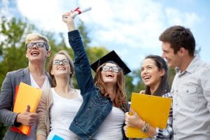 Education, graduation and people concept - group of smiling students in mortarboard with diploma and school folders