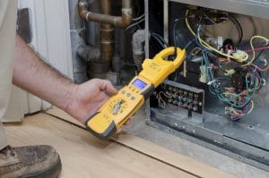 HVAC technician checking the amperage on a residential heat pump