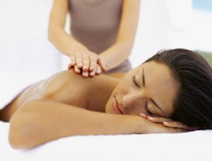 close-up of a young woman getting a back massage from a massage therapist
