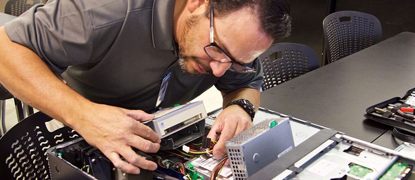 An IntelliTec College Computer Systems Technician student works on a CPU