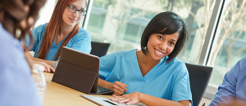 Healthcare employees sitting together in a meeting.